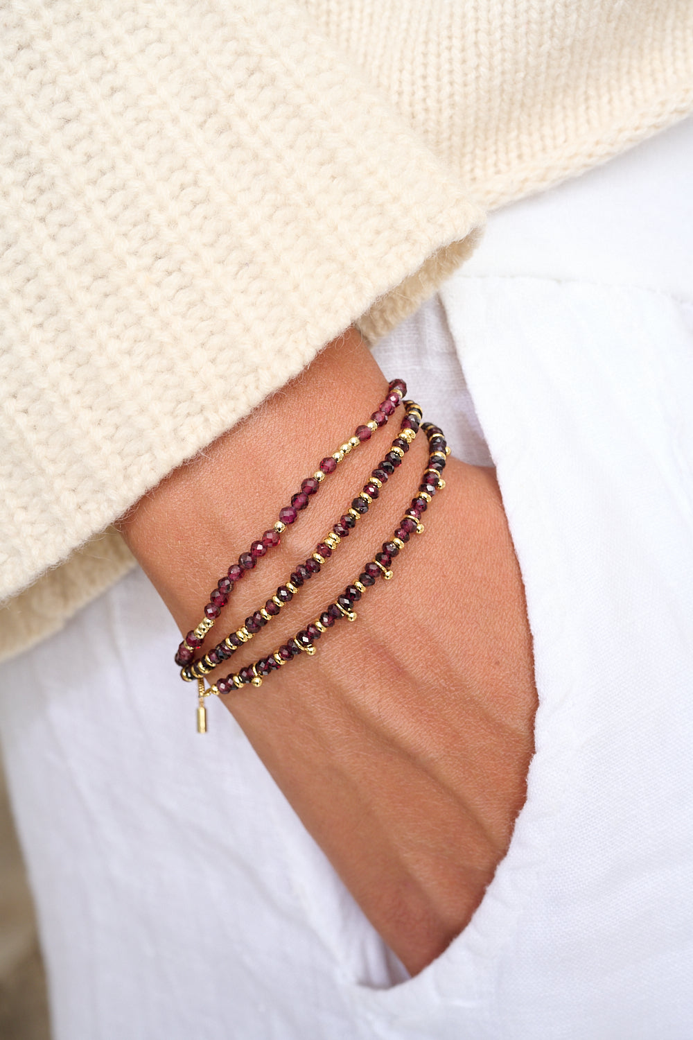 Harmony Garnet gold gemstone bracelet styled on wrist with Boho Betty gold stacking bracelets