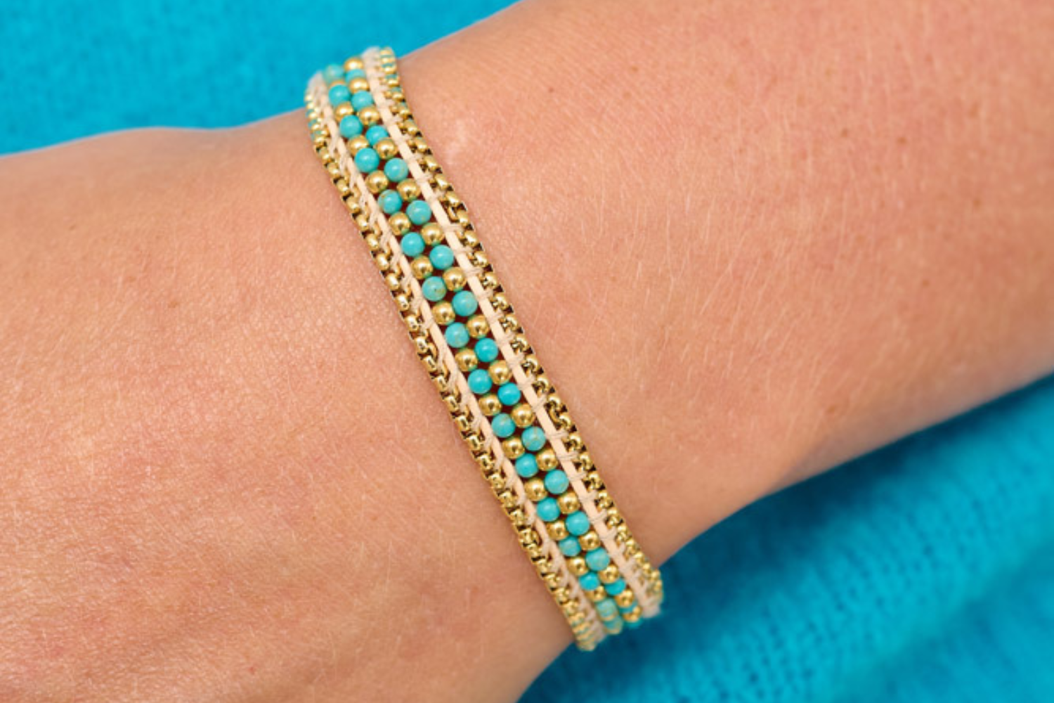 Isla Turquoise Gold Braided Bracelet styled on the wrist, featuring a braided design with turquoise howlite beads and gold accents, perfect for a boho-chic, beach-ready look.