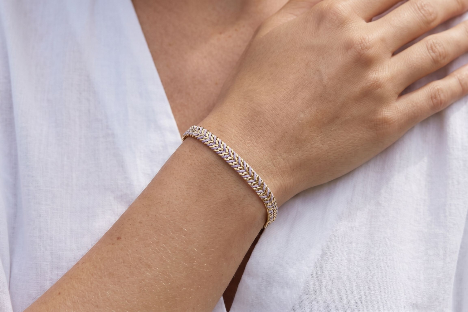 Iztac Lilac and Gold Braided Bracelet styled on the wrist, showcasing soft lilac woven detailing and warm gold accents for relaxed boho styling.