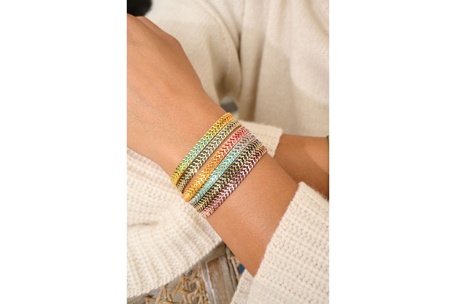 Iztac Rainbow Gold Braided Bracelet styled on the wrist, showcasing vibrant threads and polished silver links for a bold, travel-inspired look.