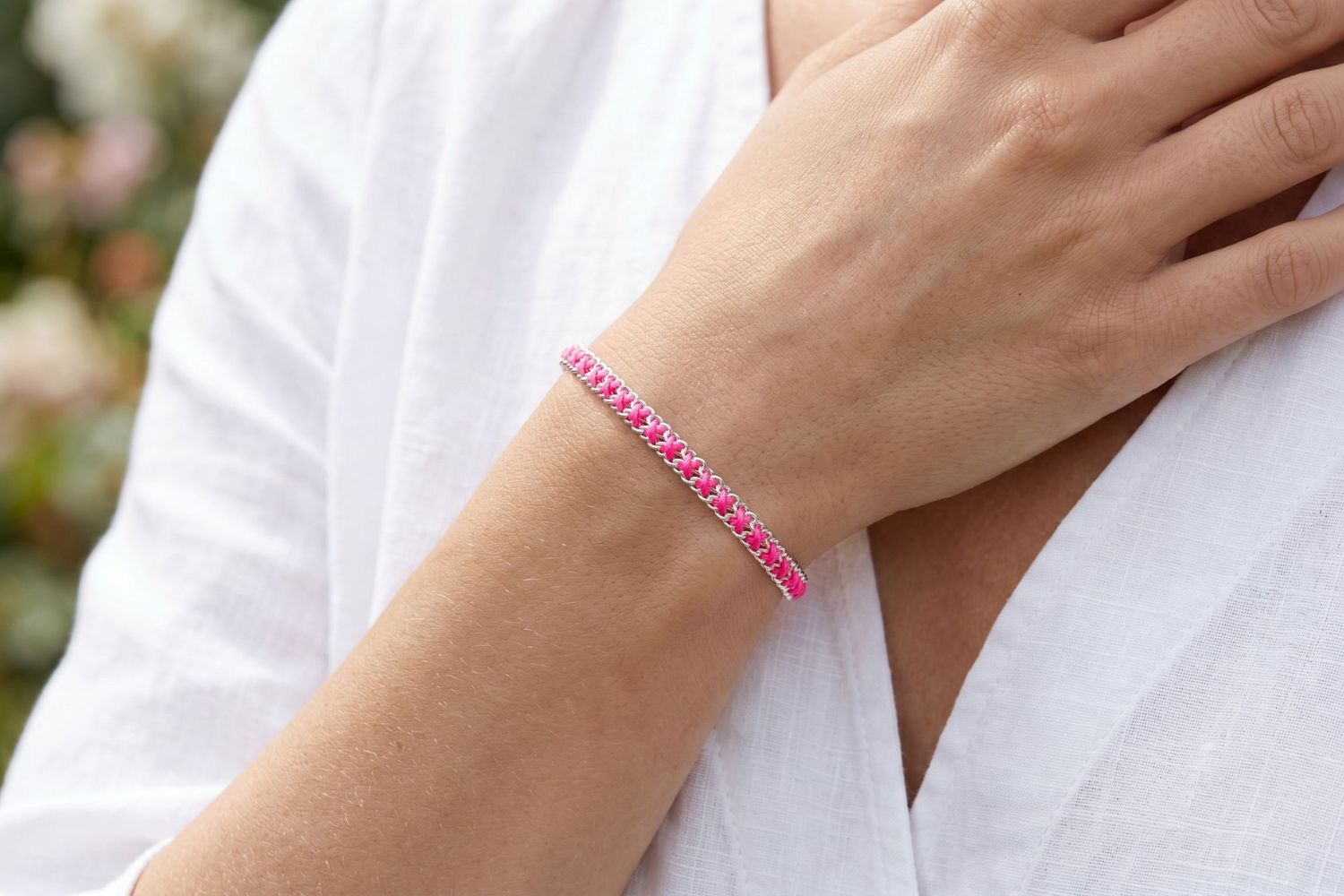 Lilia Hot Pink Silver Woven Bracelet styled on the wrist, showing bright pink woven detailing and cool silver accents for playful boho styling.
