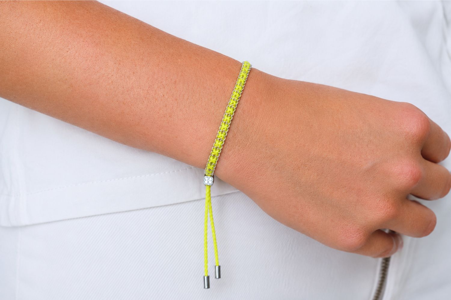 Lilia Silver & Neon Yellow Woven Bracelet styled on the wrist, showcasing bold neon woven detailing and polished silver accents for playful boho styling.