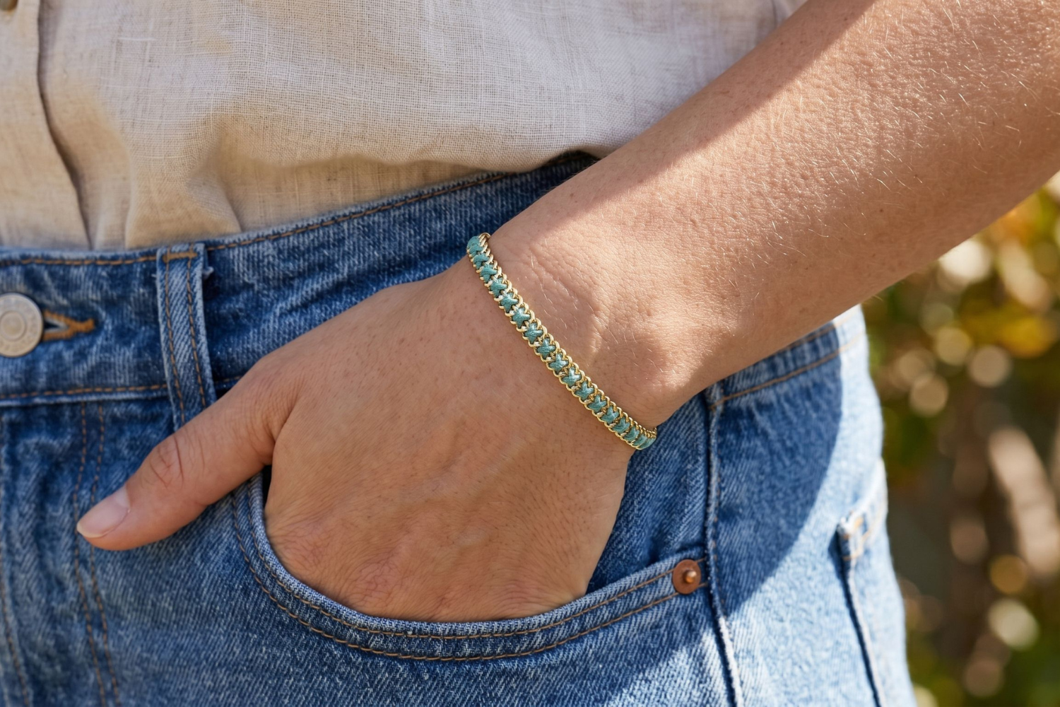 Lilia Teal Gold Woven Bracelet styled on the wrist, showcasing colourful teal woven detailing and warm gold accents for relaxed boho styling.