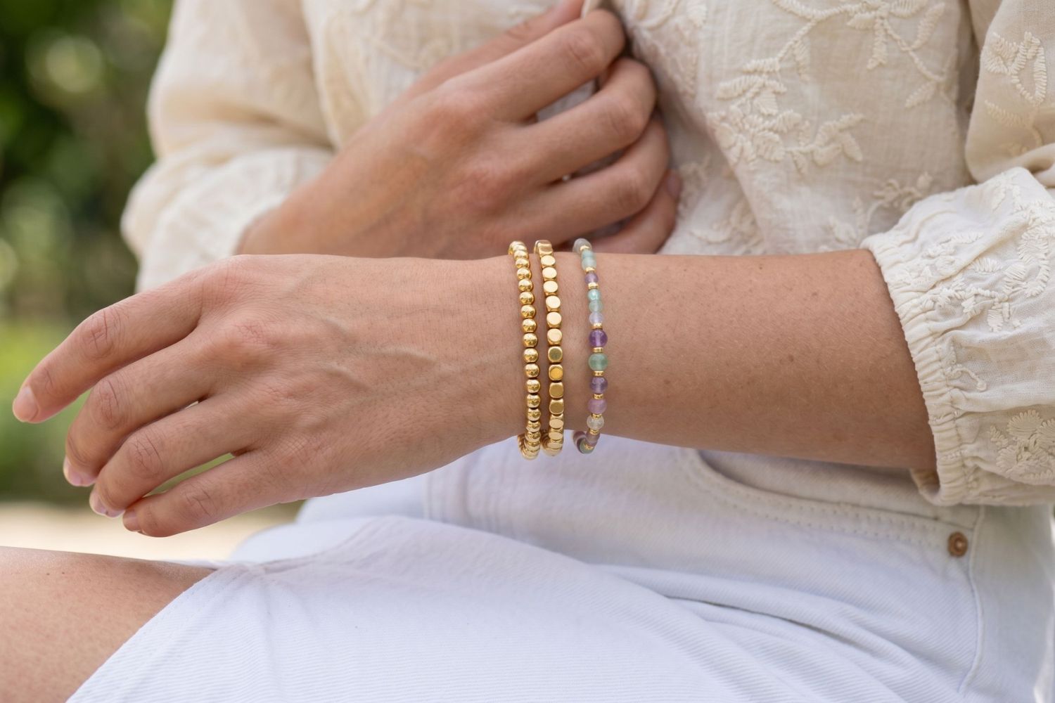 Makena Rainbow Fluorite & Gold Bracelet Stack styled on the wrist, showcasing rainbow fluorite gemstones and layered gold bead bracelets for effortless everyday styling.