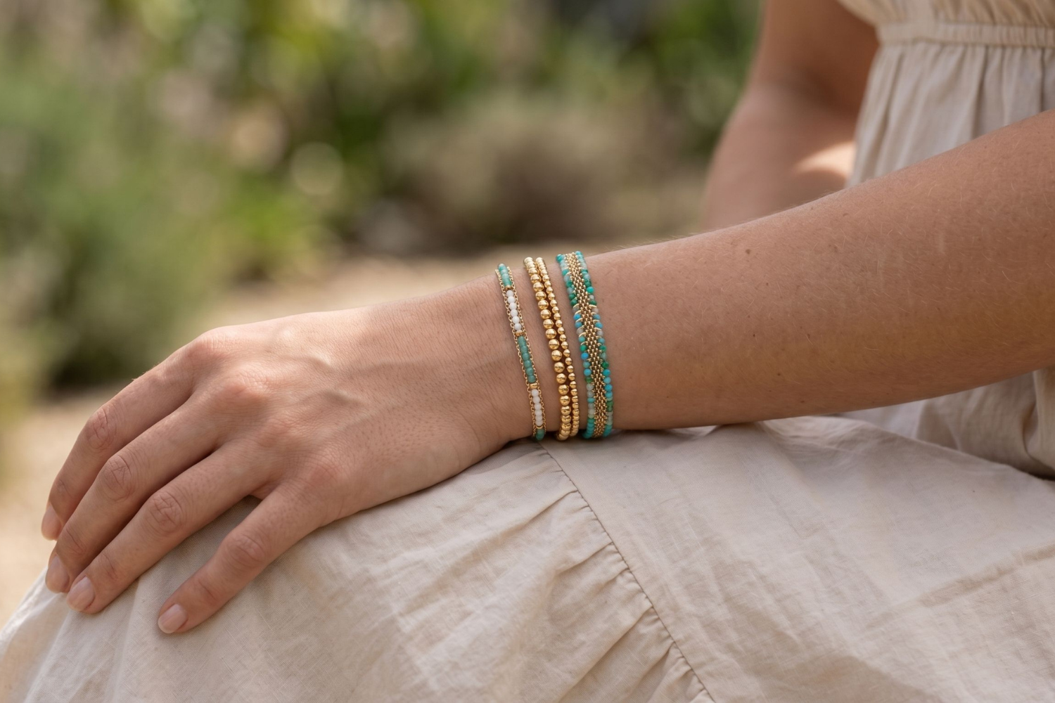Martinique Turquoise and Gold Bracelet Stack styled on the wrist, showcasing layered turquoise gemstone beads, gold textures and woven bracelet detailing for relaxed coastal styling.