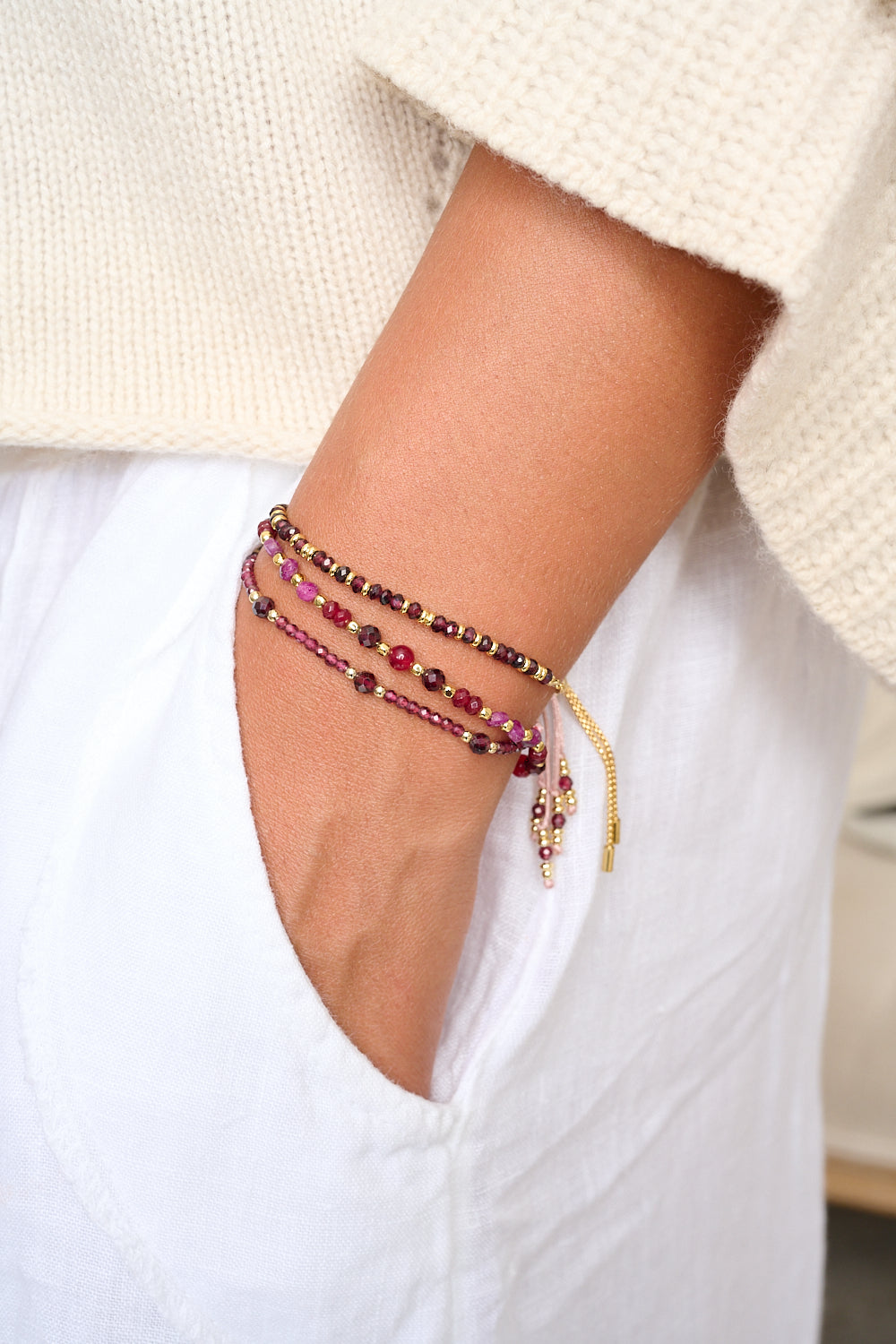 Meadow Garnet Gold Friendship Bracelet featured on wrist, styled with Boho Betty stacking bracelets in a relaxed, boho-chic look.