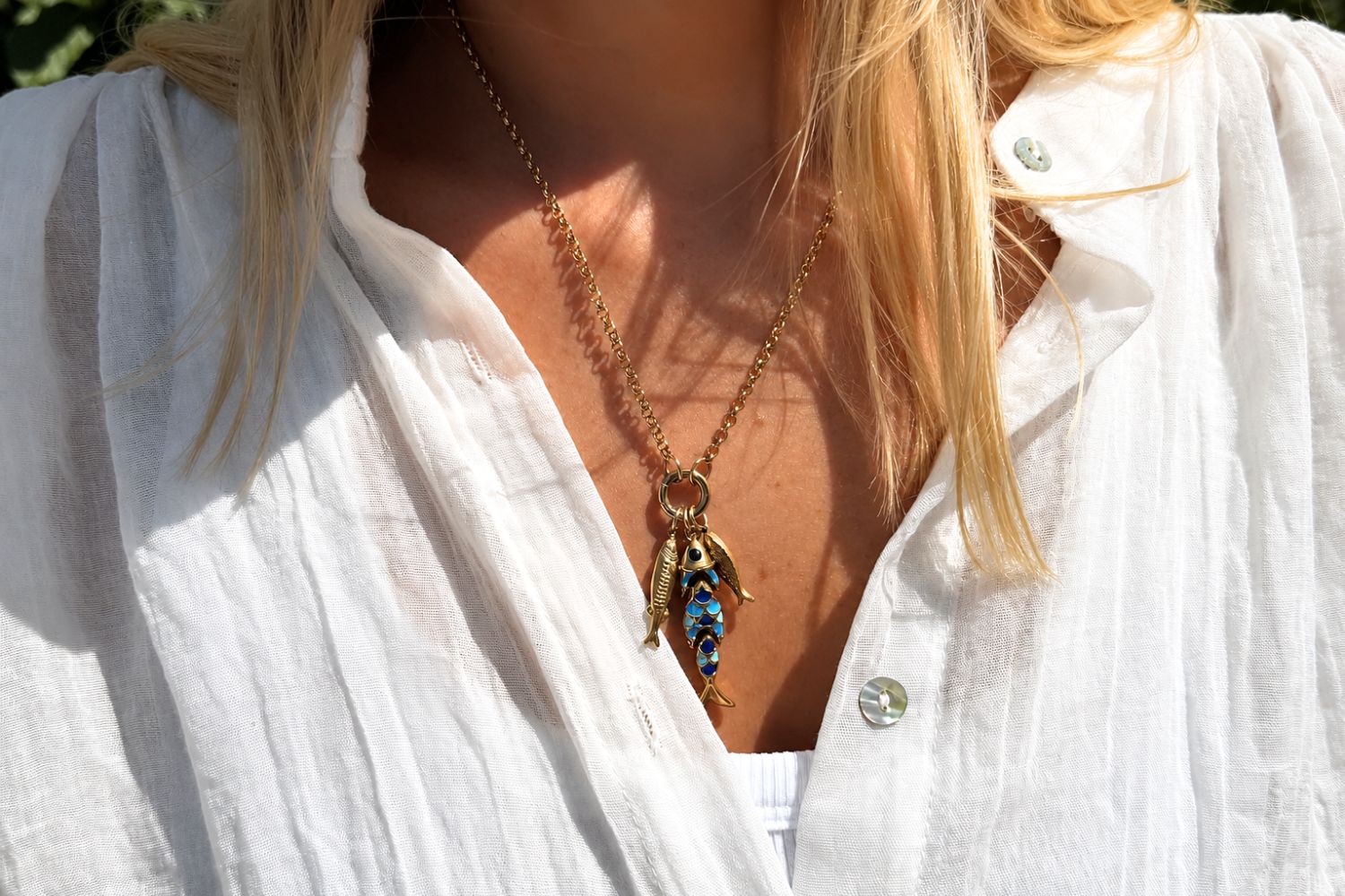 Minami Blue Ombre Waterproof Gold Fish Cluster Necklace worn on the neckline, showcasing a trio of fish charms including a blue ombré enamel fish on a chunky waterproof 14k gold PVD charm carrier chain inspired by the ocean.