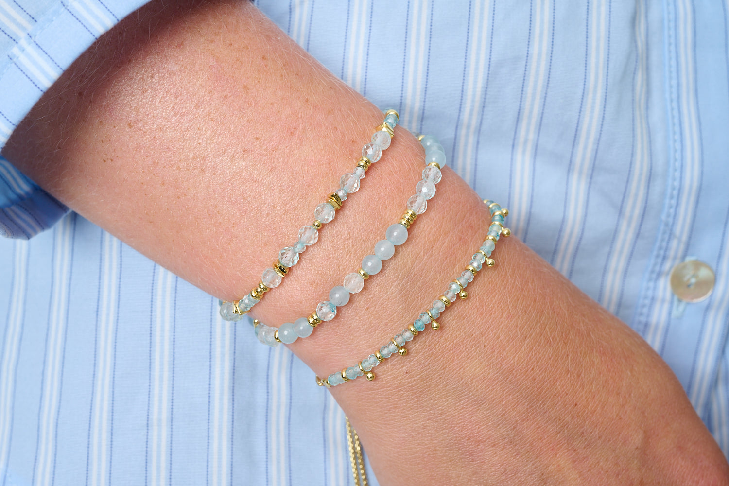 Moala blue topaz gold bracelet stack, faceted blue topaz gemstone bracelets with polished gold accents and adjustable slider fits