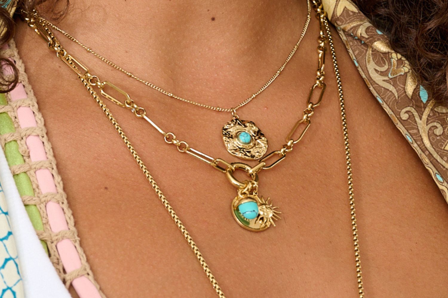 Nerissa Amulet Necklace styled with beachwear and gold jewellery layers, glowing in natural light, layered with waterproof gold chain necklaces