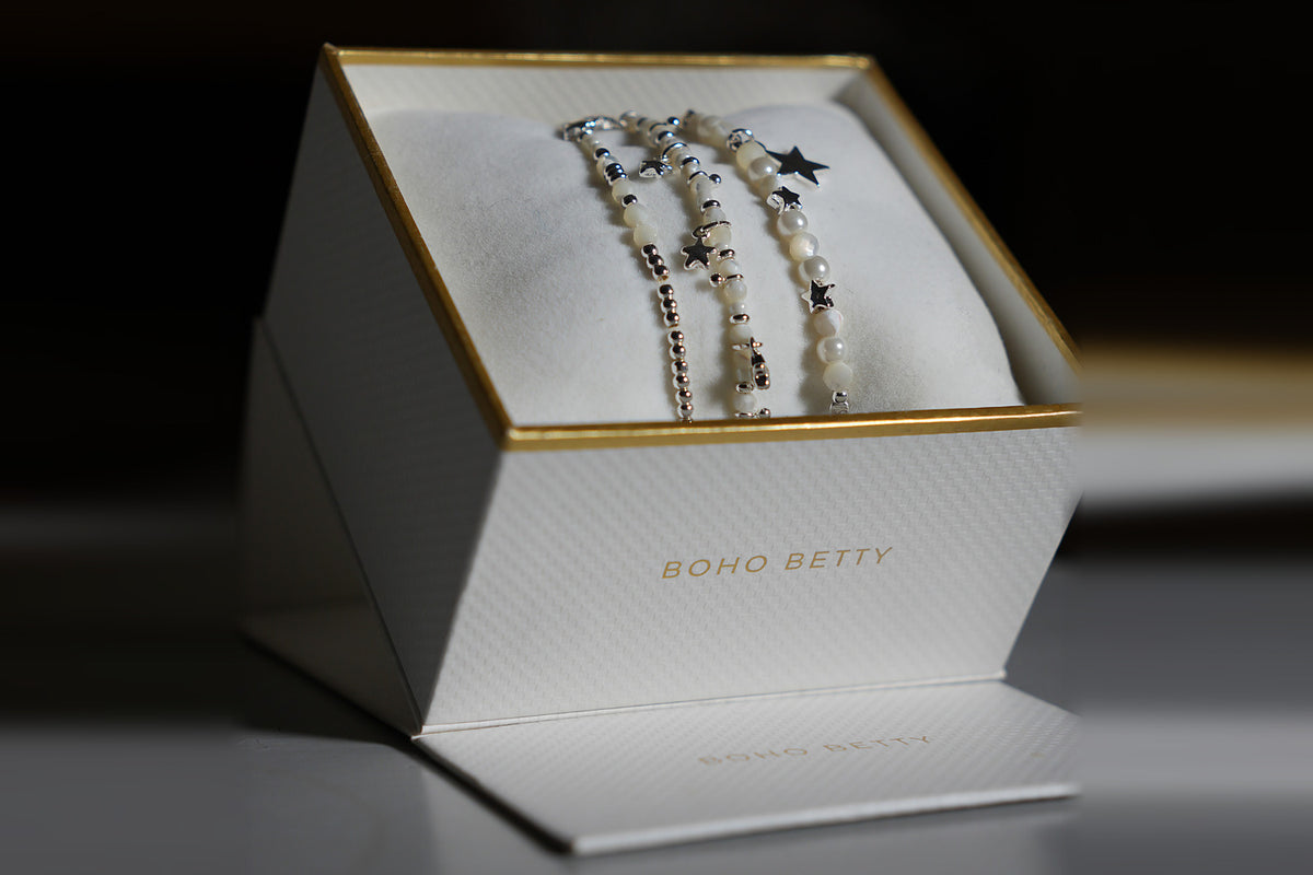 Three pearl and silver star stretch bracelets from the Orion stack in an open Boho Betty jewellery gift box