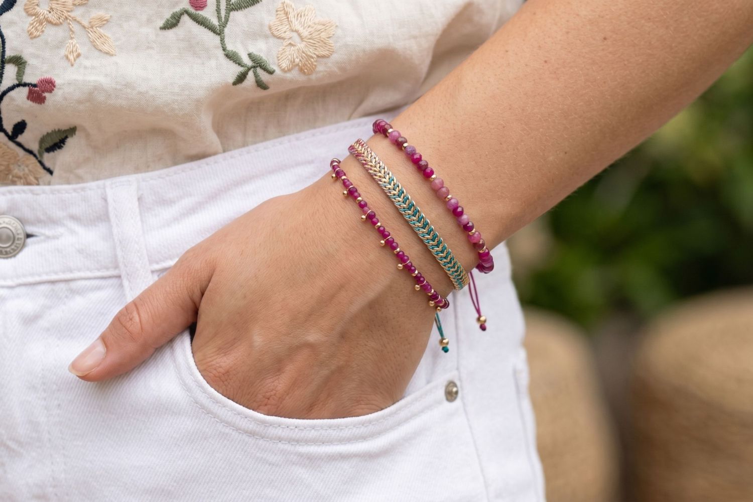 Ovos Ruby & Gold Colourful Bracelet Stack styled on the wrist, showcasing ruby gemstones, colourful woven textures and layered gold bracelet details.
