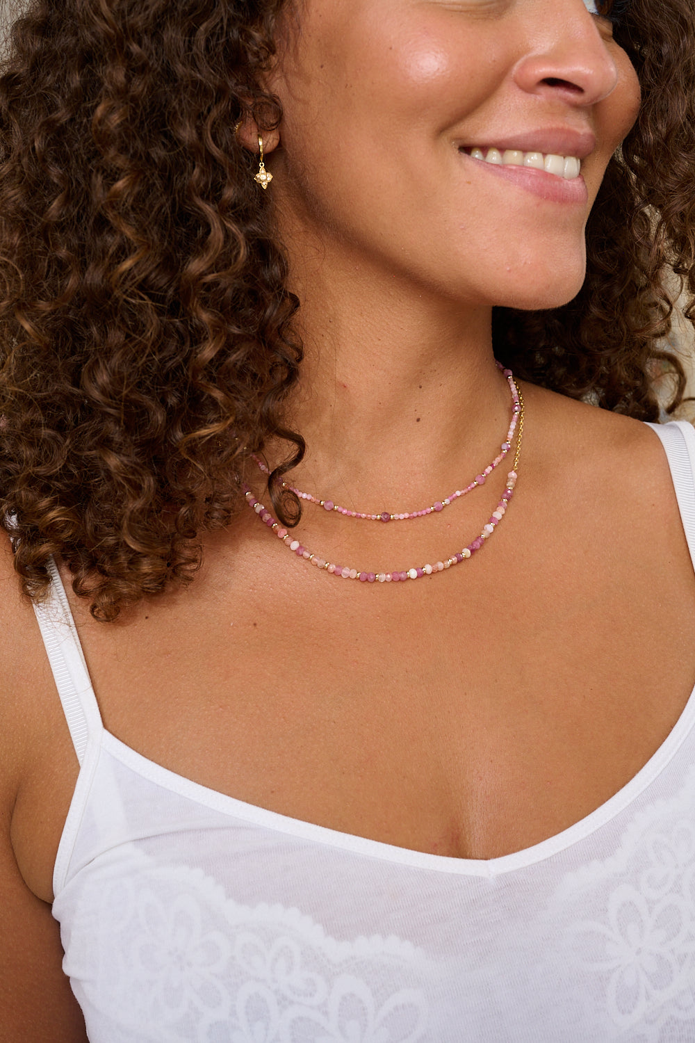 Posey Pink Tourmaline Necklace styled with layered gold jewellery and soft fabrics, creating a romantic, sunlit look.