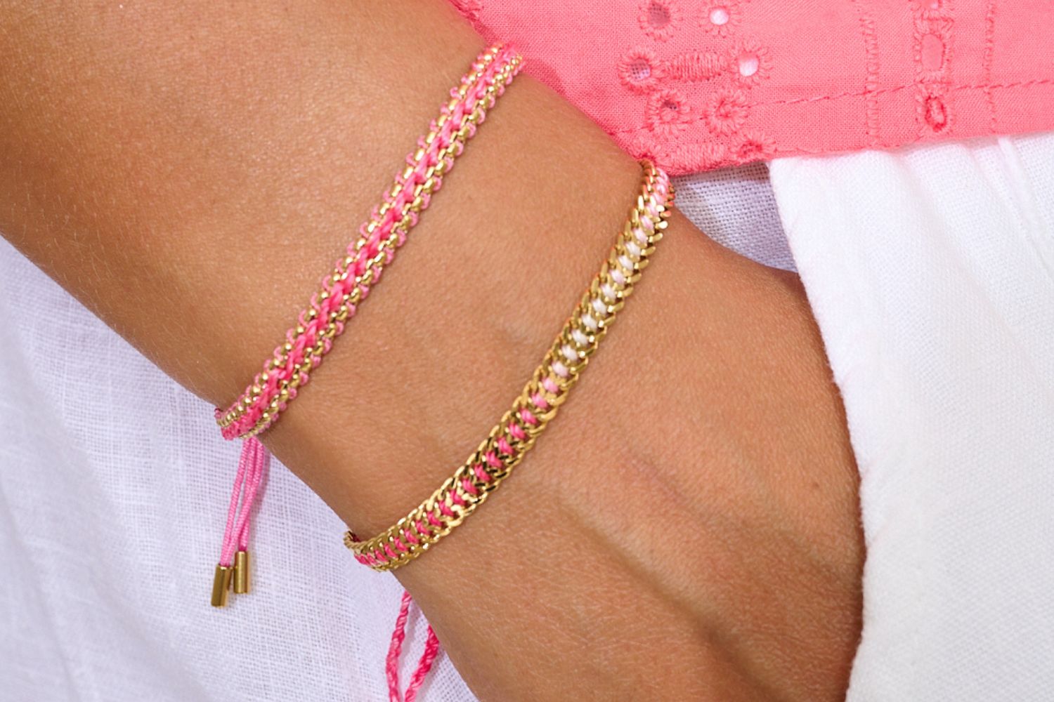 Redang Pink & Gold Bracelet Stack with Bloom snake-chain braid and Athena curb-chain braid, pink ombré thread, styled with a pink shirt and white linen trousers.