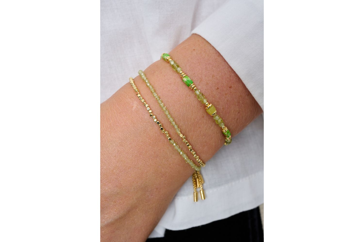 Salma Gold & Peridot Gemstone Slider Bracelet featured on wrist with Boho Betty stacking bracelets in gold and green gemstone tones.