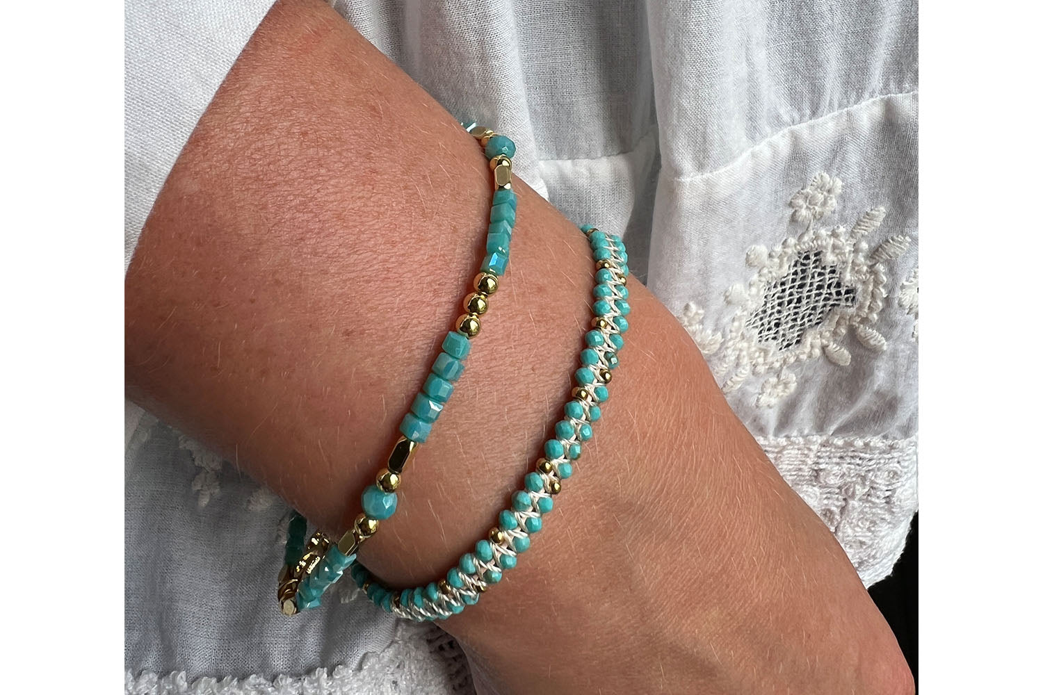 Seraphina Gold & Turquoise Stretch Bead Bracelet styled on the wrist, showcasing shimmering teal and gold accents—perfect for stacking or wearing solo.