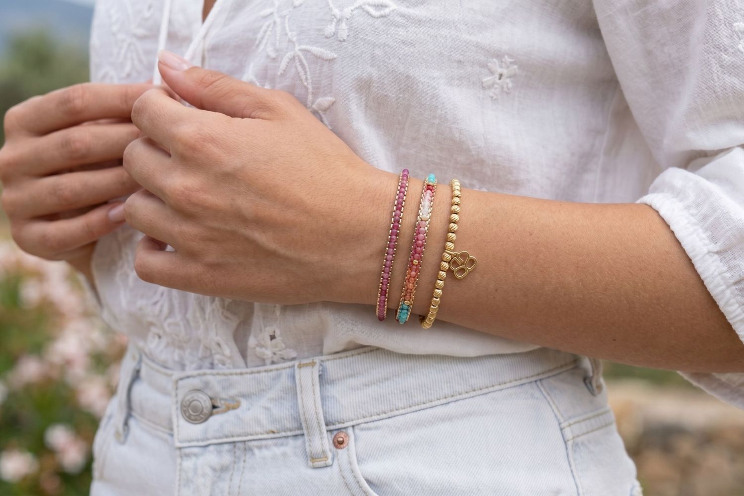 Socotra Candy & Pink Tourmaline Gold Bracelet Stack styled on the wrist, showcasing colourful gemstone beads, pink tourmaline details and layered gold bracelet textures.