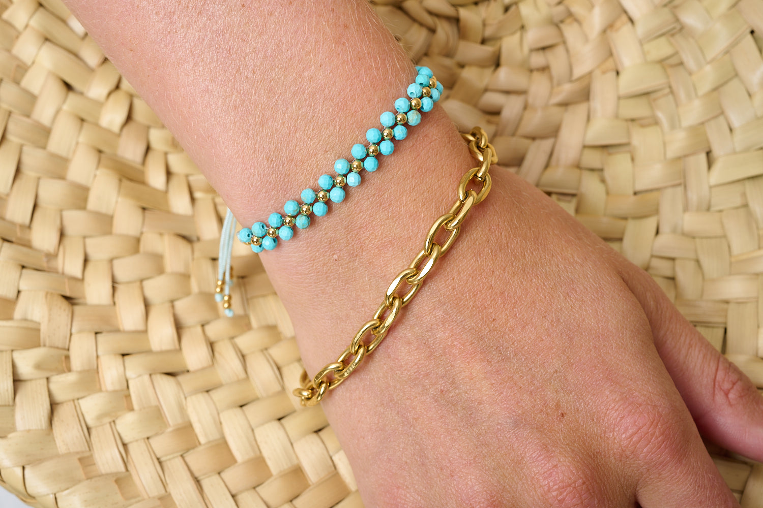 Tanna Turquoise Gold Bracelet Stack worn against a woven backdrop, bold gold chain and turquoise beaded bracelet creating a bright, beachy layered look.