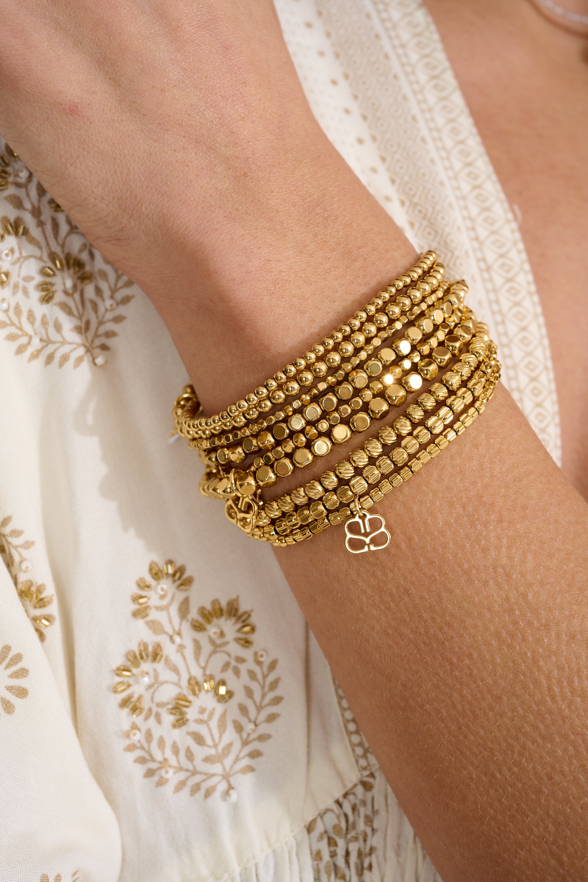Thea Gold Stretch Bead Bracelet styled for boho-inspired layering, with shimmering gold beads and Boho Betty’s filigree charm—perfect for beach parties, sunset cocktails, and everyday sparkle.