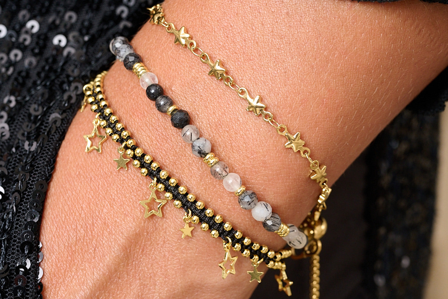 Vanatu Black Rutilated Quartz & Gold Star Bracelet Stack styled on wrist with layered celestial gold and black bracelets