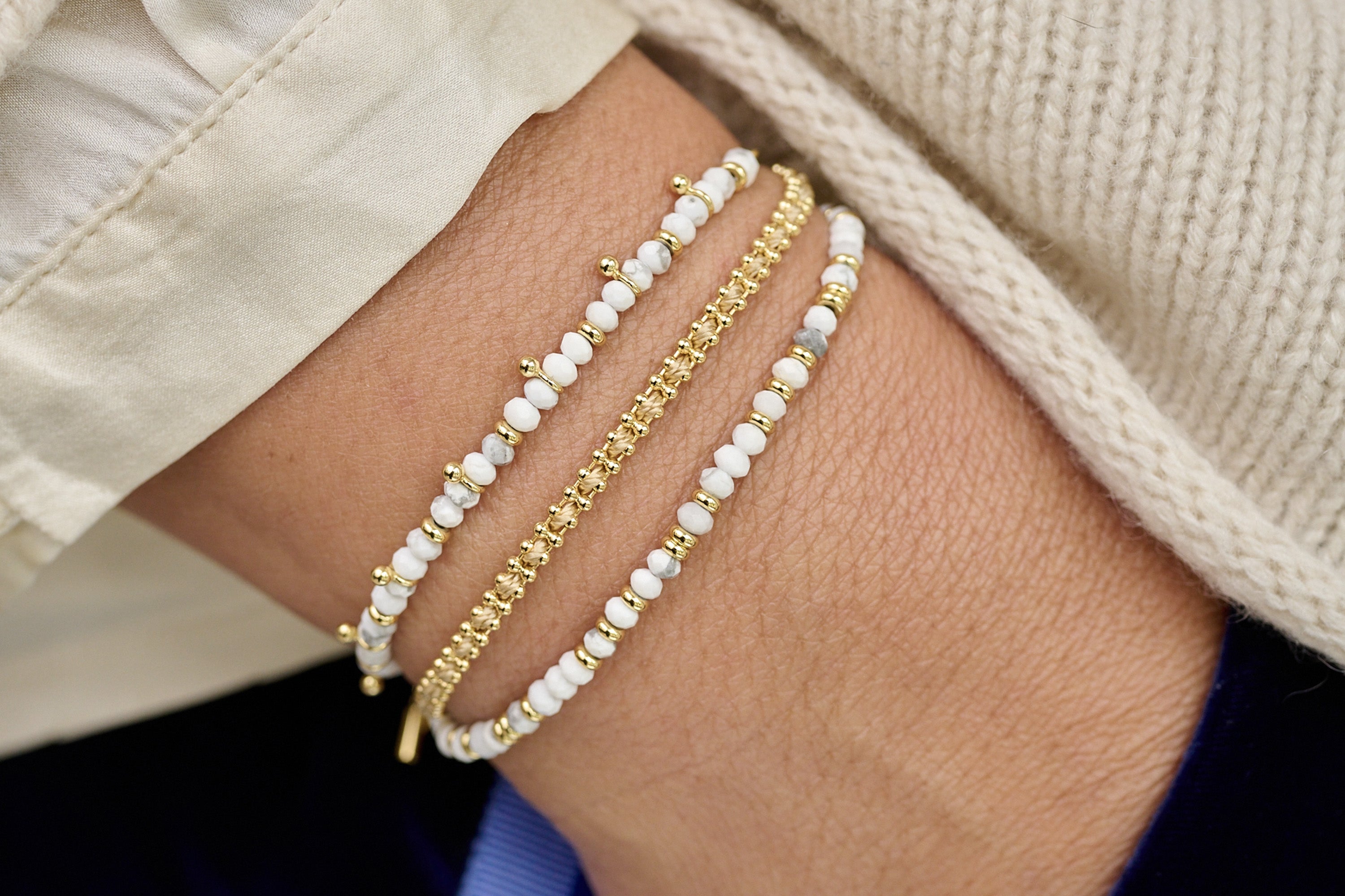 Braid Salmon Gold Bracelet lifestyle shot styled with other bracelets
