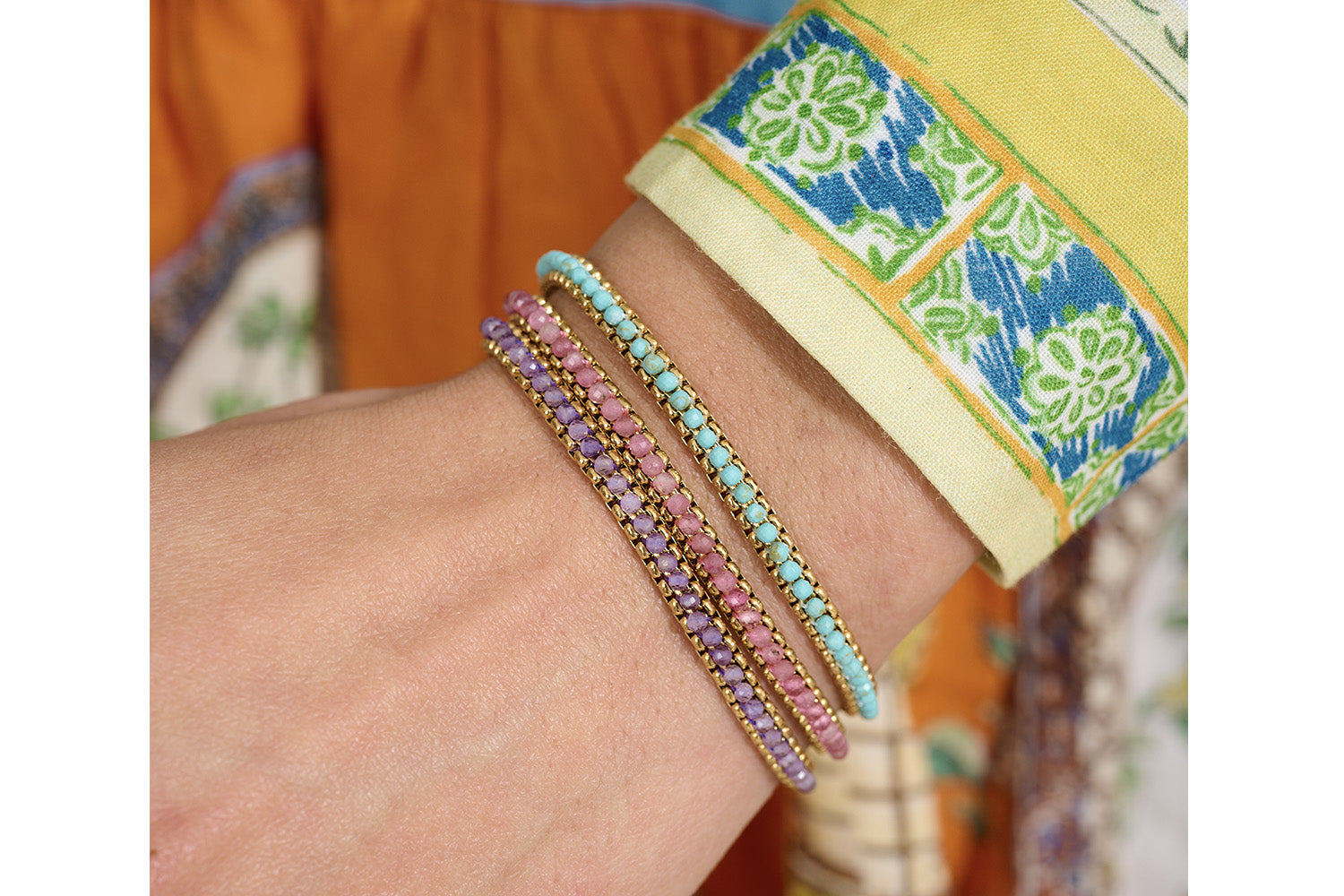 Zena Pink Tourmaline Gold Braided Bracelet styled on the wrist, showcasing vibrant pink hues and shimmering gold accents, perfect for layering or wearing solo.