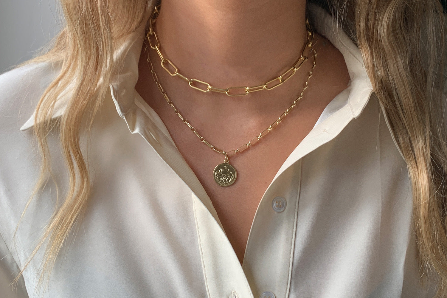 Notus Gold Chunky Chain Necklace styled with a tailored outfit, showcasing its elongated geometric links and gold-plated finish for a striking, modern look.